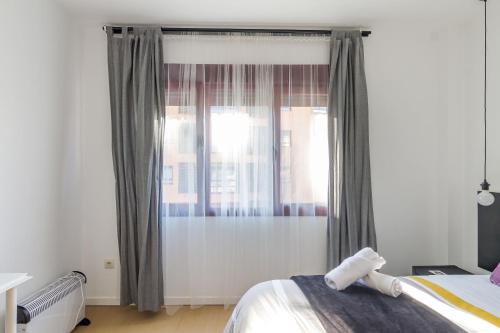 a bedroom with a bed and a window with curtains at AYZ Javier Cabrini - Auto check-in property in Madrid
