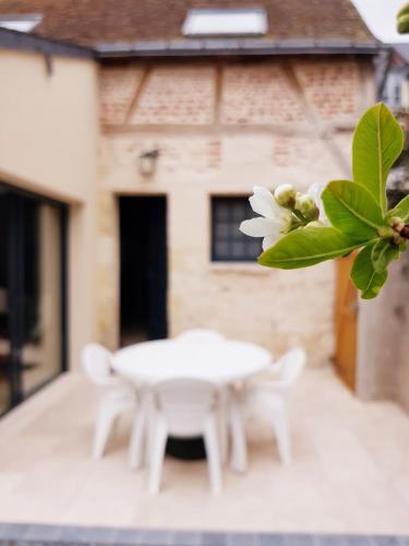 a white table and two white chairs in front of a building at La Parenthèse in Amboise