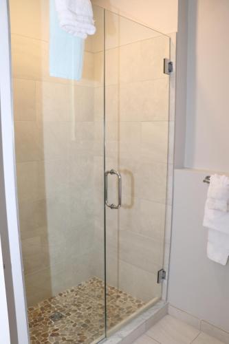 a shower with a glass door in a bathroom at A Stylish Stay w/ a Queen Bed, Heated Floors.. #1 in Brookline