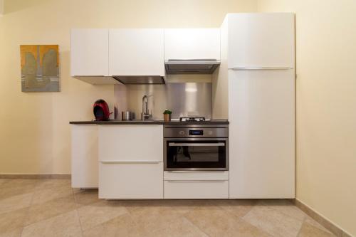 een witte keuken met een fornuis en een koelkast bij Narciso Centralissimo in Sanremo