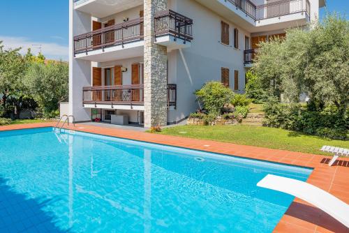 a villa with a swimming pool in front of a house at Casa Claire in Bardolino