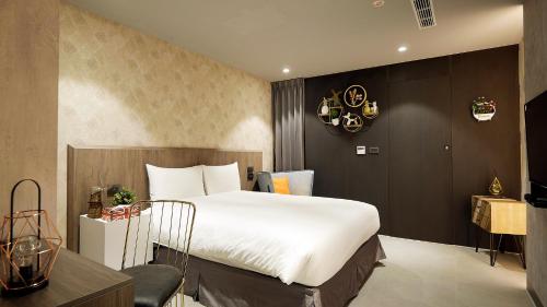 a bedroom with a large white bed and a table at K HOTEL in Taichung