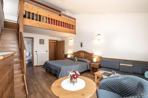 a hotel room with a bed and a living room at Hotel San Martino in San Martino di Castrozza
