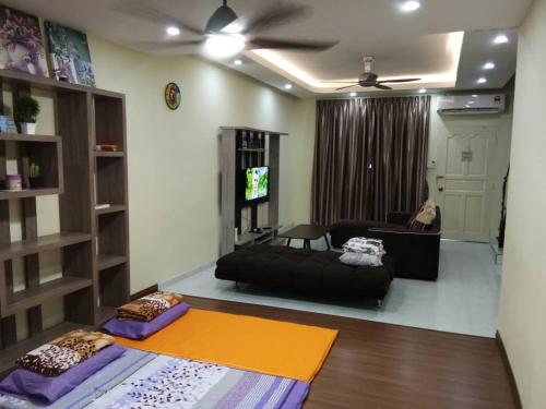 a living room with a couch and a ceiling fan at D'Gaia Homestay Sandakan in Sandakan