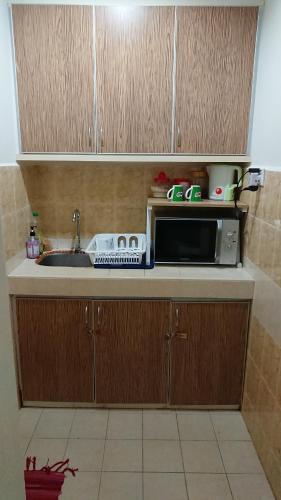 a kitchen counter with a microwave and a sink at AlRayani Guest Room, Homestay Kota bharu in Kota Bharu