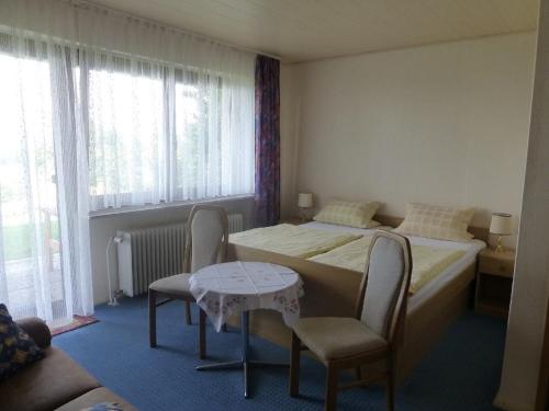 Maroldsweisach的住宿－Ferienwohnung Margit Altenstein，酒店客房带两张床和一张桌子以及椅子。