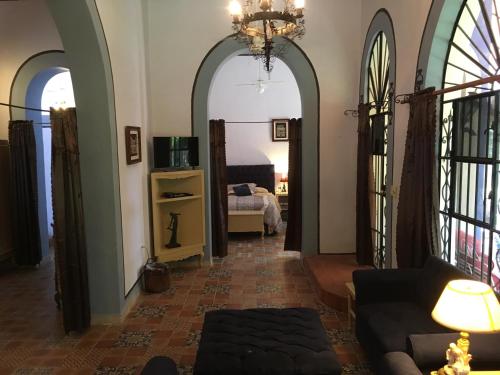 a living room with a couch and a room with a bed at Hacienda San Pedro Nohpat in M&eacute;rida