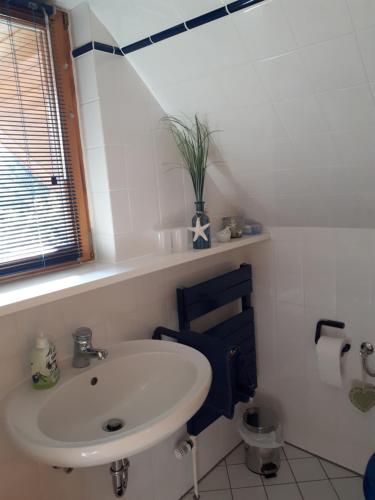 a bathroom with a sink and a blue chair at Appartement Rose in Hechthausen