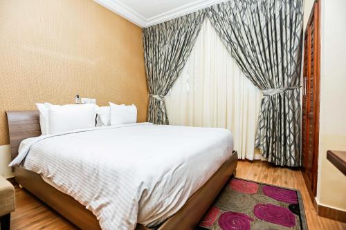 a bedroom with a large bed and a window at Jeyads Lodge in Tamale