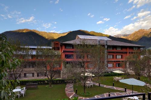 a large building with a garden in front of it at Honeymoon Inn Manali in Manāli