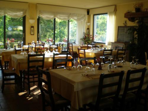 uma sala de jantar com mesas, cadeiras e janelas em Locanda Verbena em Stresa