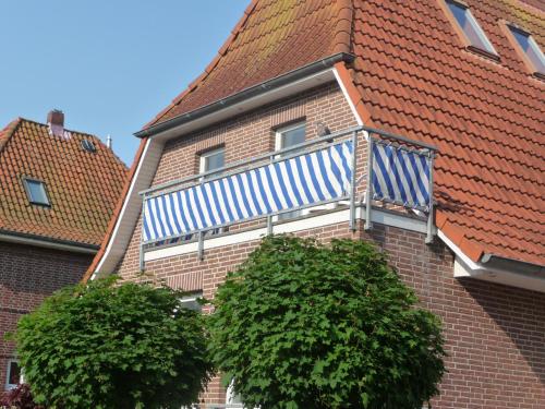 un edificio con un balcone blu e bianco di Strandhaus am Kurpark a Cuxhaven