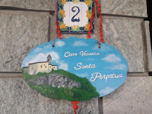 a sign on a wall with a picture of a church at Casa Vacanze Santa Perpetua in Tirano