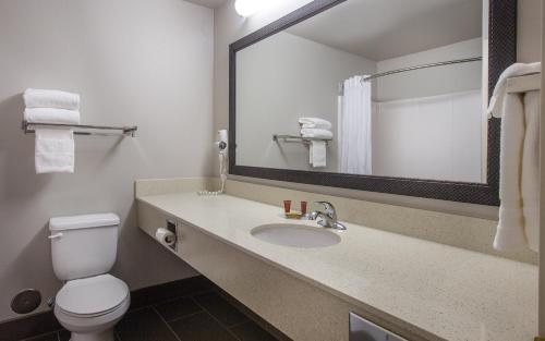 a bathroom with a toilet and a sink with a mirror at Coast Hilltop Inn in Pullman