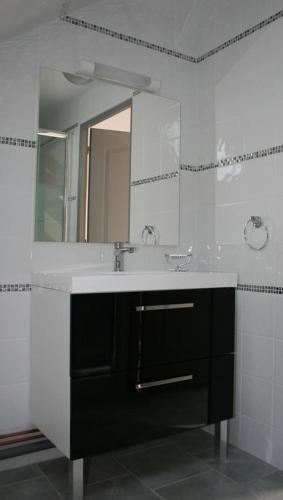 une salle de bain avec un lavabo et un miroir dans l'établissement Au gîte du treuil, à Monchy-au-Bois