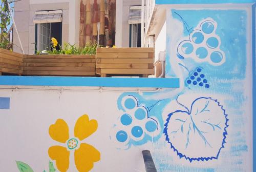 a wall with a painting of grapes and flowers at Lagoas in Tavira
