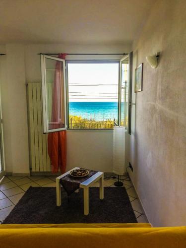 Una habitación con una mesa y vista al mar. en A Cà d'Assunta, en Laigueglia