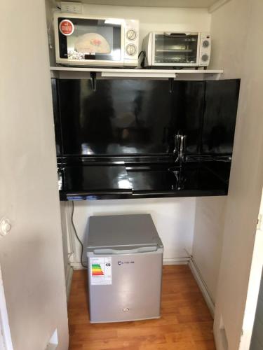 a small kitchen with a microwave and a refrigerator at Rent apart Las Condes in Santiago