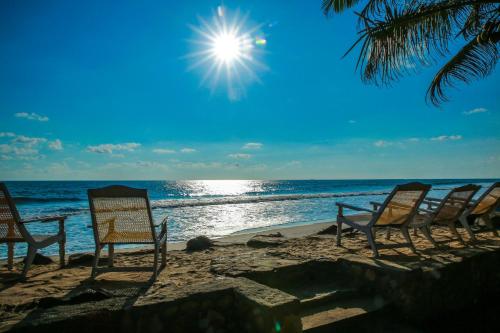 a group of chairs sitting on the beach at Kodi Beach Home in Galle