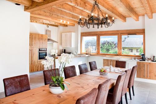 a kitchen and dining room with a wooden table and chairs at Chambres d'hôtes La Grangelitte in Doussard