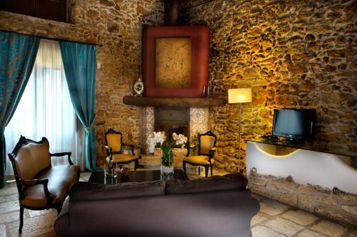 a living room with a couch and a stone wall at Il Baglio Della Luna Relais by Le Dhome Sicily in Balestrate