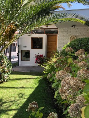 a garden with a house with a gate and flowers at Rent apart Las Condes in Santiago