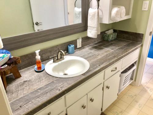 a bathroom counter with a sink and a mirror at Fishers Of Men Ranch Home in Marble Falls