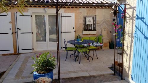une terrasse avec une table et des chaises. dans l'établissement Chambre et table d'hôtes Villa Pomponette, à Nans-les-Pins