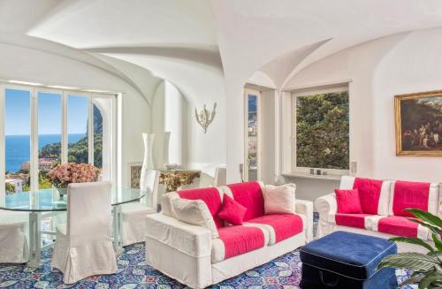 a living room with two chairs and a glass table at Villa Silia in Capri