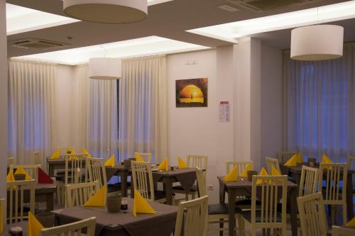 un comedor con mesas y sillas amarillas en Hotel Villa Enea, en Cattolica