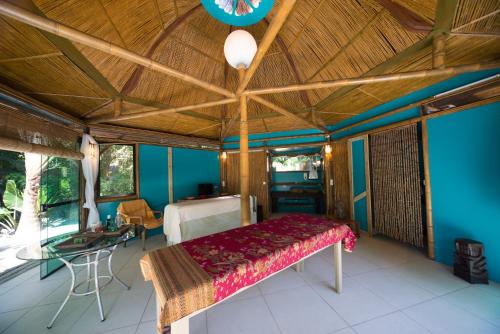 1 dormitorio con 1 cama en una habitación con paredes azules en Pousada Treze Luas, en Ilha do Mel