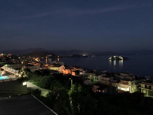 a night view of a city and a body of water at lovely studio with awesome view in Tolo
