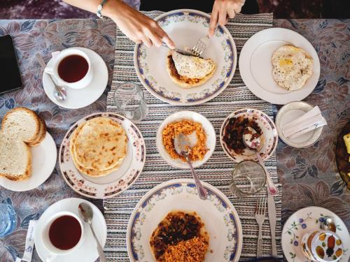 uma mesa com pratos de comida e chávenas de café em Holiday Stay Inn em Kandy