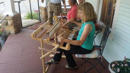 a woman sitting on a chair playing a guitar on a porch at Wildflower Bed and Breakfast in Mountain View