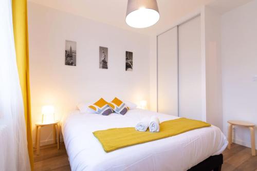 une chambre avec un lit blanc avec deux serviettes dessus dans l'établissement Chez Jules - Tram, Bus, 8 pers., 3ch, wifi, à Villeurbanne