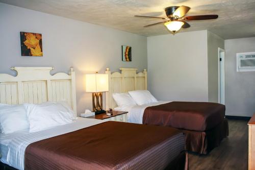 a hotel room with two beds and a ceiling fan at Zwolle Inn in Zwolle