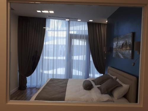 a bedroom with a large mirror above a bed at Apartment Tbilisi in King David in Tbilisi City
