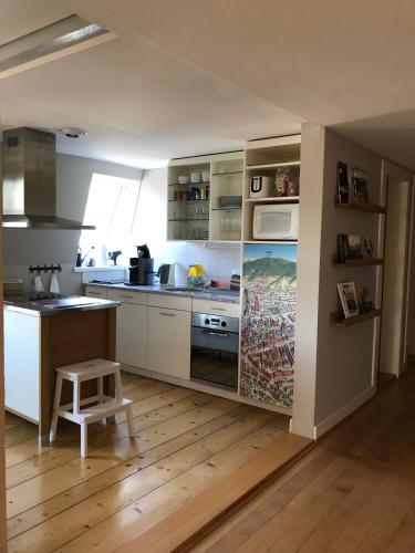 a kitchen with white cabinets and a stool in it at Villa Jakobsbrunnen in Winterthur