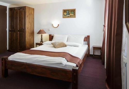 a bedroom with a large bed with white sheets at Casa Maria Valea Draganului in Lunca Vişagului