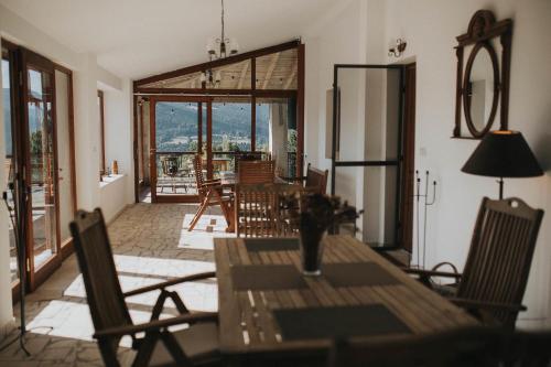 comedor con mesa y sillas y balcón en Casa Maria Valea Draganului, en Lunca Vişagului