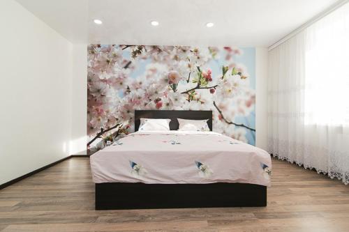 1 dormitorio con 1 cama con pared de flores en 16 вулиця Прокоф'єва, en Sumy