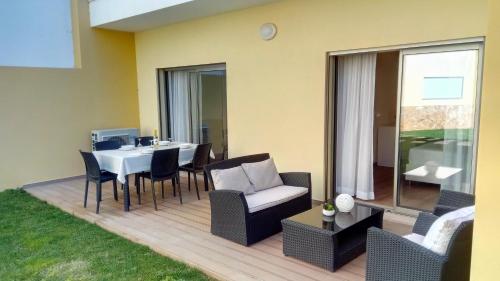 a patio with a table and chairs and a dining room at Apartamento O Jardins da Marina in Albufeira
