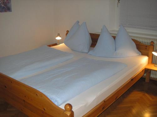 a large bed with white sheets and pillows at Ferienwohnungen Familie Jarnig Inge in Görtschach
