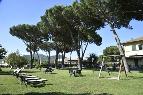 a park with benches and a swing set at Agriturismo Redipuglia in Alberese