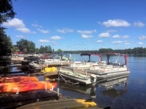a group of boats docked at a dock on a lake at Clear Lake Resort in West Branch
