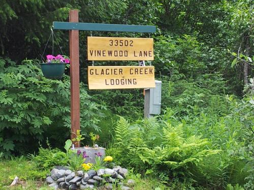 un panneau indiquant un jardin et un panneau indiquant une cour dans l'établissement Glacier Creek Lodging, à Seward