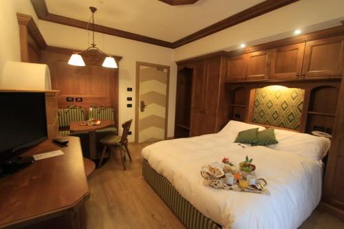 a bedroom with a bed with a tray of fruit on it at Dolasilla Park Hotel in Vigo di Fassa