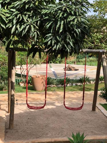 two red ropes hanging from a tree in a park at Casa da Lua Pousada in Alto Paraíso de Goiás