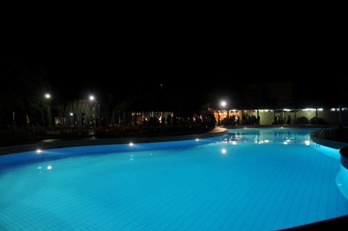 a large swimming pool lit up at night at Hotel Marrani in Ronta