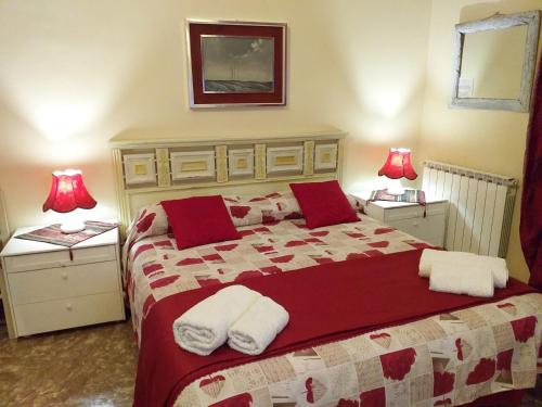 a bedroom with a large bed with red and white blankets at B&B Casa Celsi in La Spezia